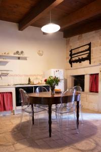 a kitchen with a wooden table with chairs and a stove at CASA RITELLA in Castellana Grotte