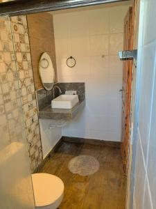 a bathroom with a toilet and a sink at Casa Tío Luiz in Aquiraz