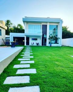 a house with a green lawn in front of it at Casa ilha Itaparica in Armação do Tairu