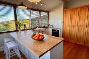 a kitchen with a bowl of oranges on a counter at Renovated Cottage Near Cataract Gorge Launceston in Royal Park +35 photos