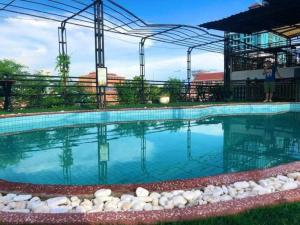 ein großer Swimmingpool mit einer Frau, die daneben steht in der Unterkunft Le Hotel Phnom Penh in Phnom Penh