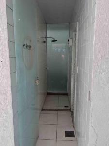 een badkamer met een douche en een glazen deur bij Apartamento com vista para o mar in Vitória