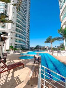 een zwembad naast een hoog gebouw bij Apartamento com vista para o mar in Vitória