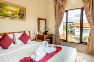 a hotel room with two beds with towels on them at Rama House in Ubud