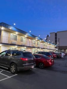 un estacionamiento con autos estacionados frente a un edificio en Columbus Motor Inn, en Seattle