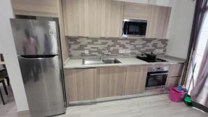 uma cozinha com um frigorífico de aço inoxidável e um lavatório em Acasia Luxury Home Cantonment em Acra
