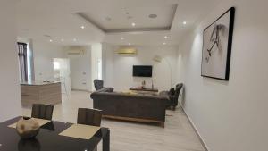 Acasia Luxury Home Cantonment في آكرا: غرفة معيشة مع أريكة وطاولة