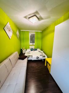 Habitación verde con cama y sofá en Family - Room, en Viena