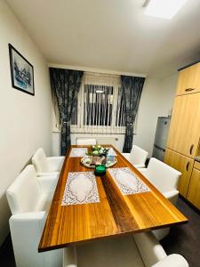 comedor con mesa de madera y sillas blancas en Family - Room, en Viena