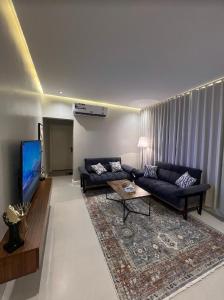 uma sala de estar com um sofá e uma televisão em شقق سمارت انترى بالملقا em Riyadh