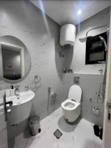 a white bathroom with a toilet and a sink at شقق سمارت انترى بالملقا in Riyadh