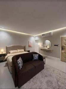 um quarto com uma cama, um sofá e um espelho em شقق سمارت انترى بالملقا em Riyadh