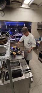 een chef-kok die maaltijden bereidt in een restaurantkeuken bij MANGROVE BEACH in Sanyang