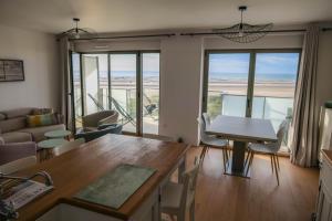 a living room with a table and chairs at Amour Baie in Berck-sur-Mer