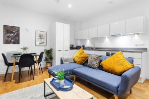 Staines upon ThamesにあるModern One Bed Apartment - Sleeps 3 - Near Heathrow, Windsor Castle, Thorpe Park - Staines London TW18の青いソファとキッチンのあるリビングルーム +14枚の写真
