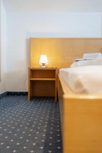 a room with two beds and a desk with a lamp at Hotel Pension Wilma in Schruns