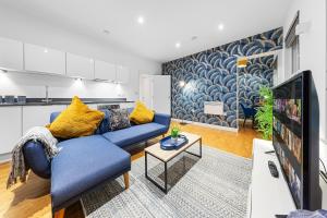 Staines upon ThamesにあるModern One Bed Apartment - Sleeps 3 - Near Heathrow, Windsor Castle, Thorpe Park - Staines London TW18の青いソファとテレビのあるリビングルーム