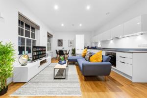 Staines upon ThamesにあるModern One Bed Apartment - Sleeps 3 - Near Heathrow, Windsor Castle, Thorpe Park - Staines London TW18の青いソファとキッチンのあるリビングルーム