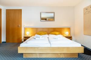 a bedroom with a bed with two pillows on it at Hotel Pension Wilma in Schruns