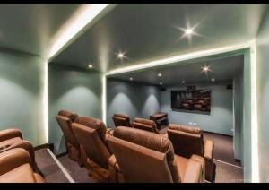 a movie room with brown chairs and a flat screen tv at Departamento Deluxe 2D in Santa Cruz de la Sierra
