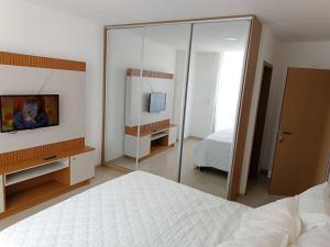 a bedroom with a white bed and a mirror at Departamento Deluxe 2D in Santa Cruz de la Sierra +11 photos