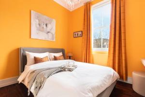 Un dormitorio con una cama con paredes naranjas y una ventana. en Stylish central London flat, en Londres