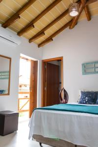 a bedroom with a bed with a blue blanket at Suítes Margarida in Ubatuba