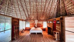 una camera da letto con un letto in una stanza con un tetto di Cabañas Casa de Agua a Boca del cielo