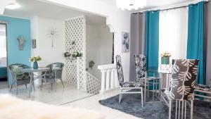 a dining room with blue walls and a table and chairs at Rowy's appartement in Willemstad