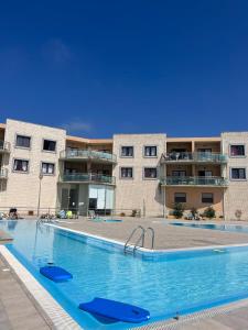 a large swimming pool in front of a building at Beach Glove Ericeira II in Ericeira