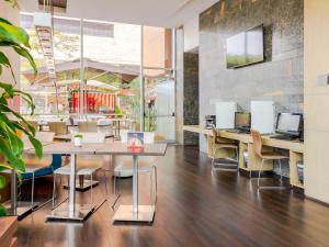 un bureau avec des tables et des chaises et des ordinateurs dans l'établissement ibis Medellin, à Medellín