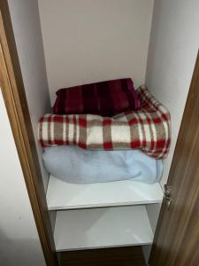 a closet with a blanket on top of a shelf at Dto Civico ART APARMENT in San Juan