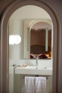 a bathroom with a sink and a mirror and a bed at Best Western Plus d'Europe et d'Angleterre in Mâcon