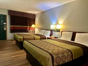 um quarto de hotel com duas camas e uma janela em Thunderbird Motor Inn em Baraboo