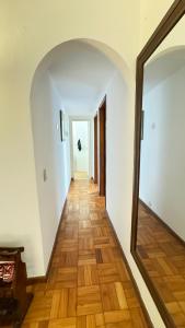 a hallway with a mirror and a wooden floor at Apart temporada Rio de Janeiro in Rio de Janeiro