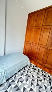 a bedroom with a bed next to a wooden door at Apart temporada Rio de Janeiro in Rio de Janeiro