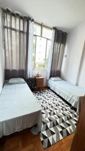 two beds in a room with a checkered floor at Apart temporada Rio de Janeiro in Rio de Janeiro