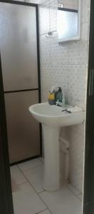 a bathroom with a white sink and a shower at quarto com banheiro privativo in Florianópolis