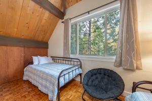 um quarto com uma cama, uma janela e uma cadeira em Pinecone Peak em Dorrington