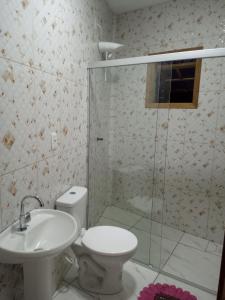 y baño con ducha, aseo y lavamanos. en Vanessa pousada familiar en São Gabriel