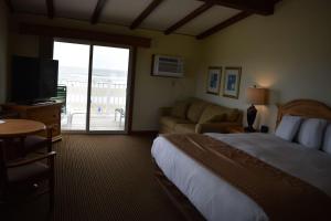 a hotel room with a bed and a sliding glass door at Norseman Resort on the Beach in Ogunquit