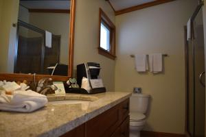 奧甘奎特的住宿－Norseman Resort on the Beach，一间带水槽、卫生间和镜子的浴室