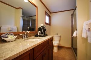 ein Badezimmer mit einem Waschbecken, einem WC und einem Spiegel in der Unterkunft Norseman Resort on the Beach in Ogunquit