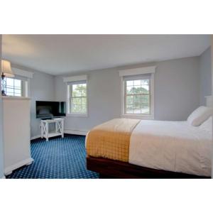 a hotel room with a bed and a television at Seacastles Resort in Ogunquit