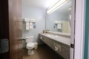 La salle de bains est pourvue de toilettes, d'un lavabo et d'un miroir. dans l'établissement Fireside Inn, Ocean's Edge, à Belfast
