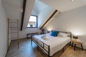 1 dormitorio con 1 cama con sábanas blancas y almohadas azules en Le Roc du Cygne charmant appartement 4 personnes à deux pas du lac, en Duingt