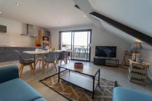 a living room with a table and a dining room at Le Roc du Cygne charmant appartement 4 personnes à deux pas du lac in Duingt