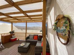 a porch with a couch and chairs on a deck at Sun Tiny House A Pahrump in Pahrump