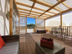 una gran terraza de madera con un banco y una mesa en Sun Tiny House A Pahrump, en Pahrump