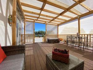 a large wooden deck with a bench and a table at Sun Tiny House A Pahrump in Pahrump